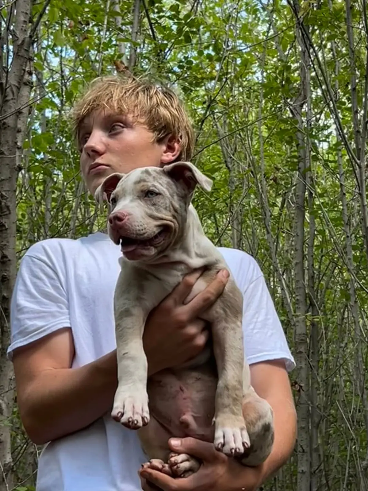 A teenager holding a puppy